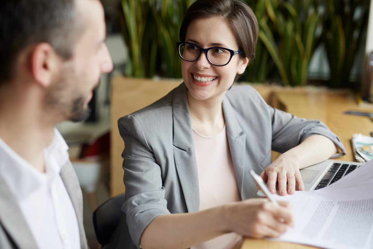 Woman signs a contract with a smile on her face