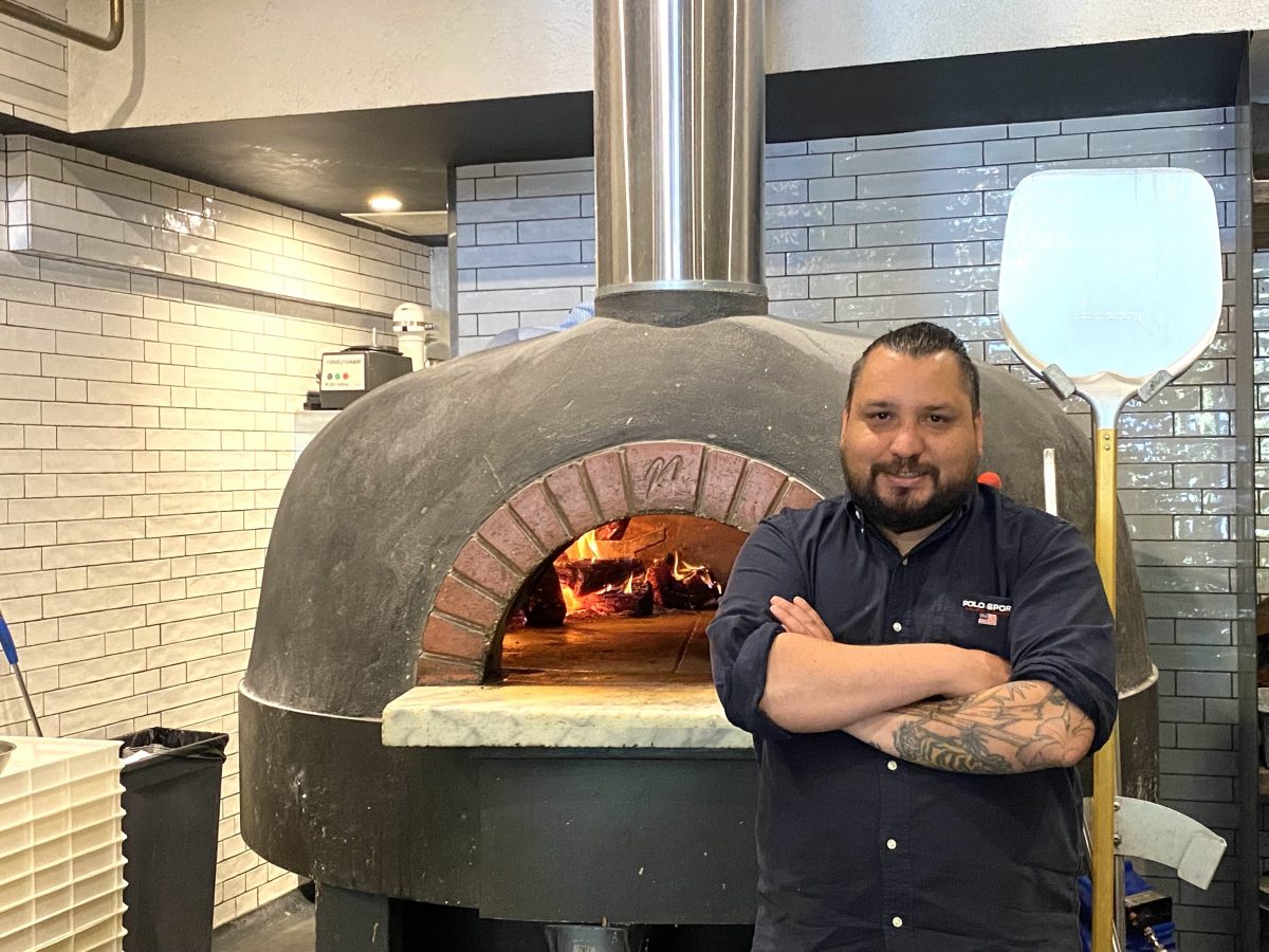 man with wood-fired pizza oven