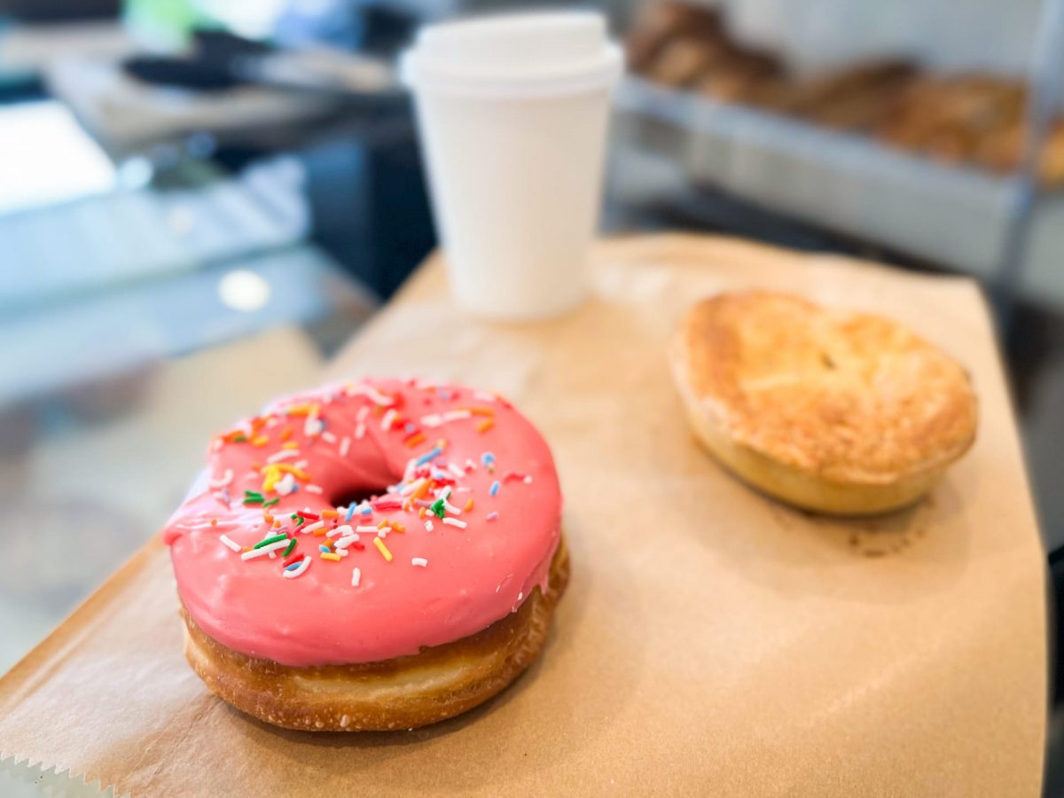 bright pink doughnut with takeaway coffee and pie