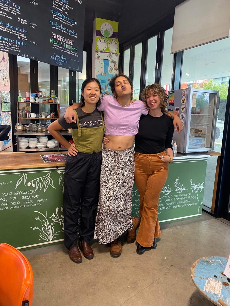 three women in front of a shop counter