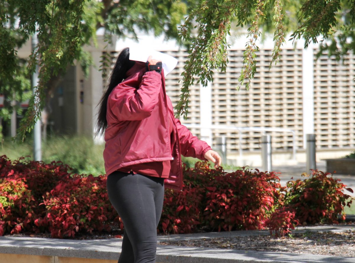 Woman walking in street covering her face
