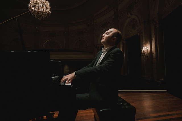 Pianist Alexander Gavrylyuk plays piano in a concert hall