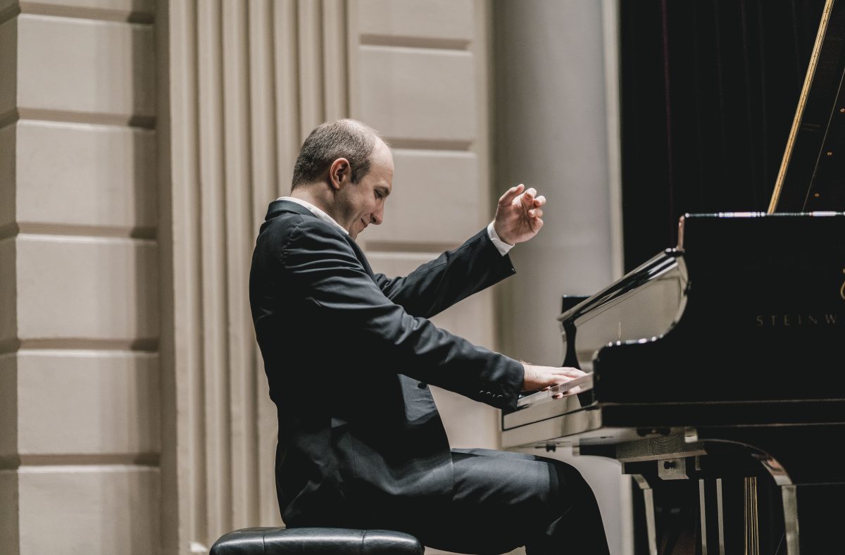 Pianist Alexander Gavrylyuk plays piano in a concert hall