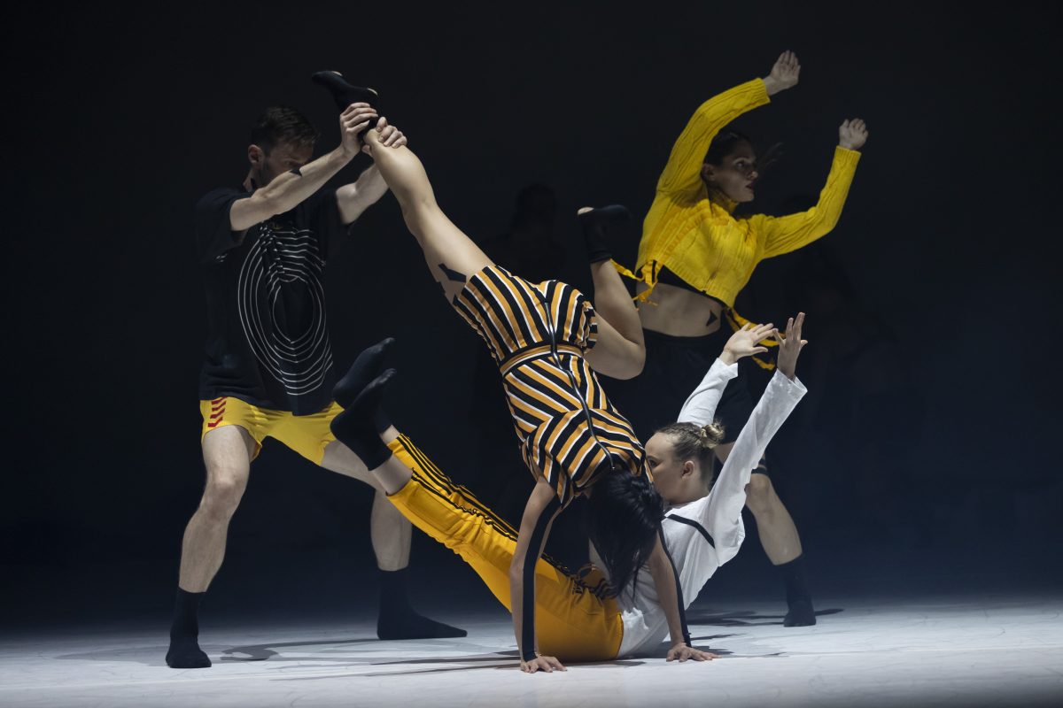 dancers in black and yello costumes on stage