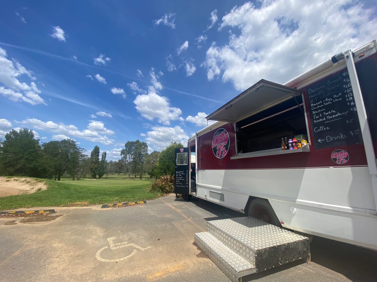 Food truck with golf course in background.