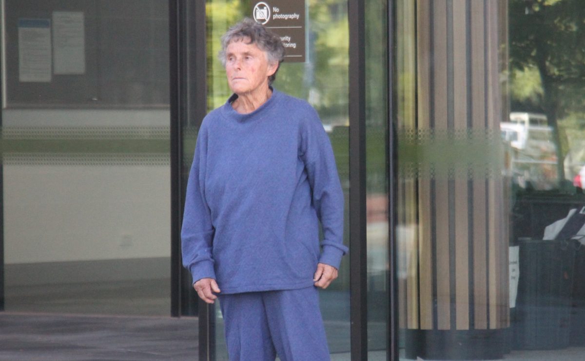 old woman in tracksuit outside court