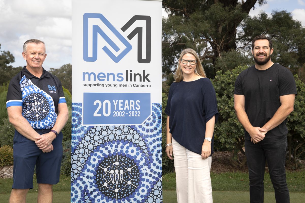 three people standing with a pull-up banner