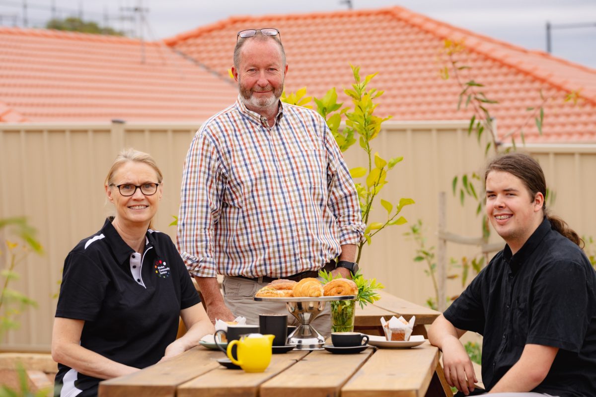 three people sitting at picnic table