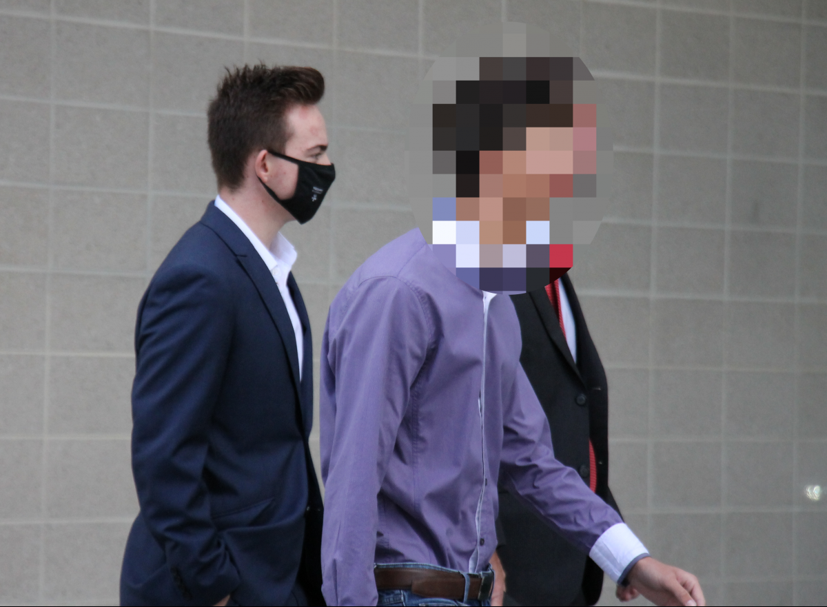 three men walking to court, two faces are pixelated 
