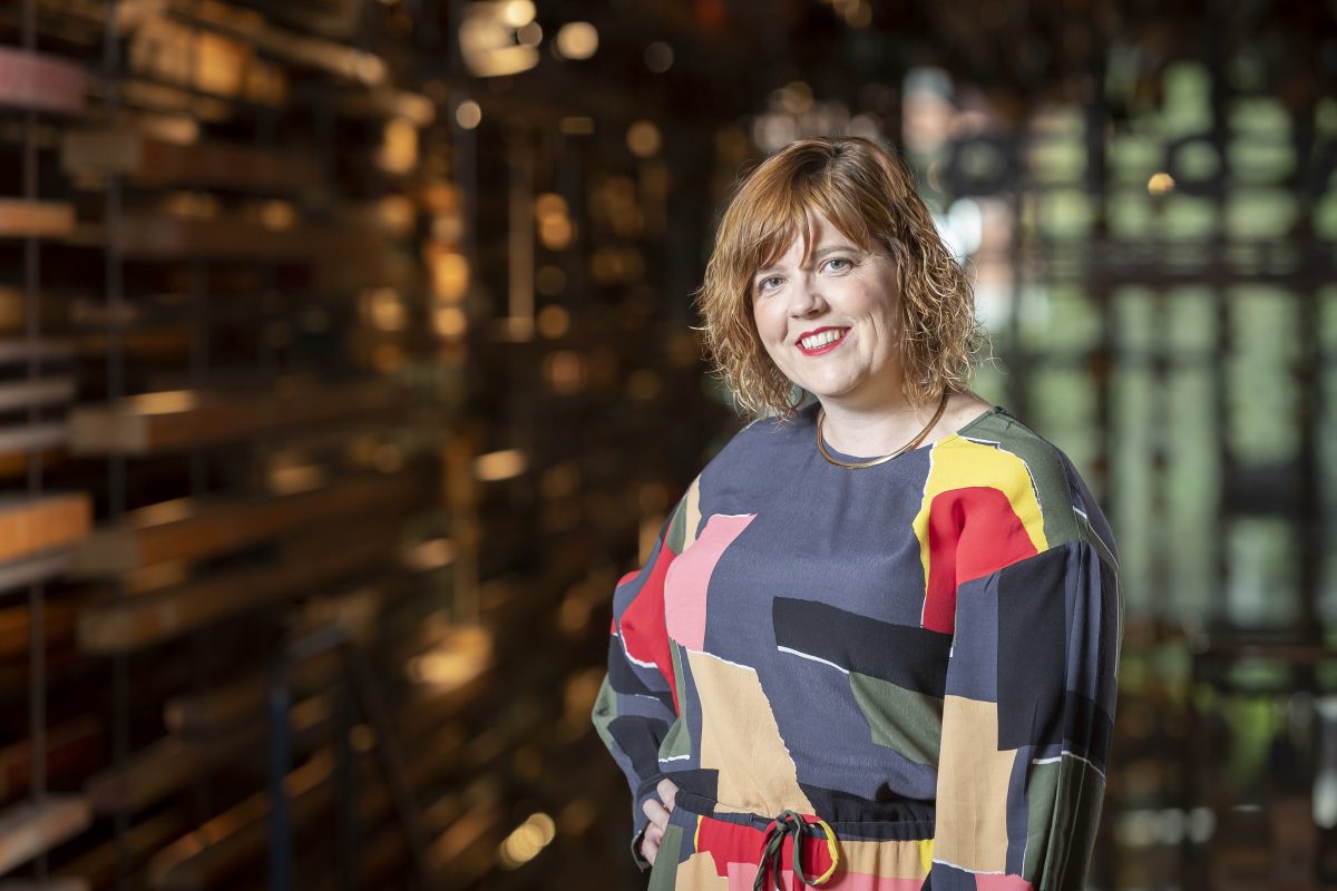 Woman in colourful geometric shirt smiles