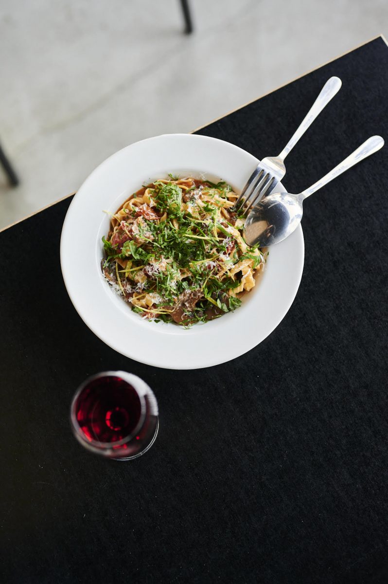 Beautiful bowl of pasta with glass of red wine.