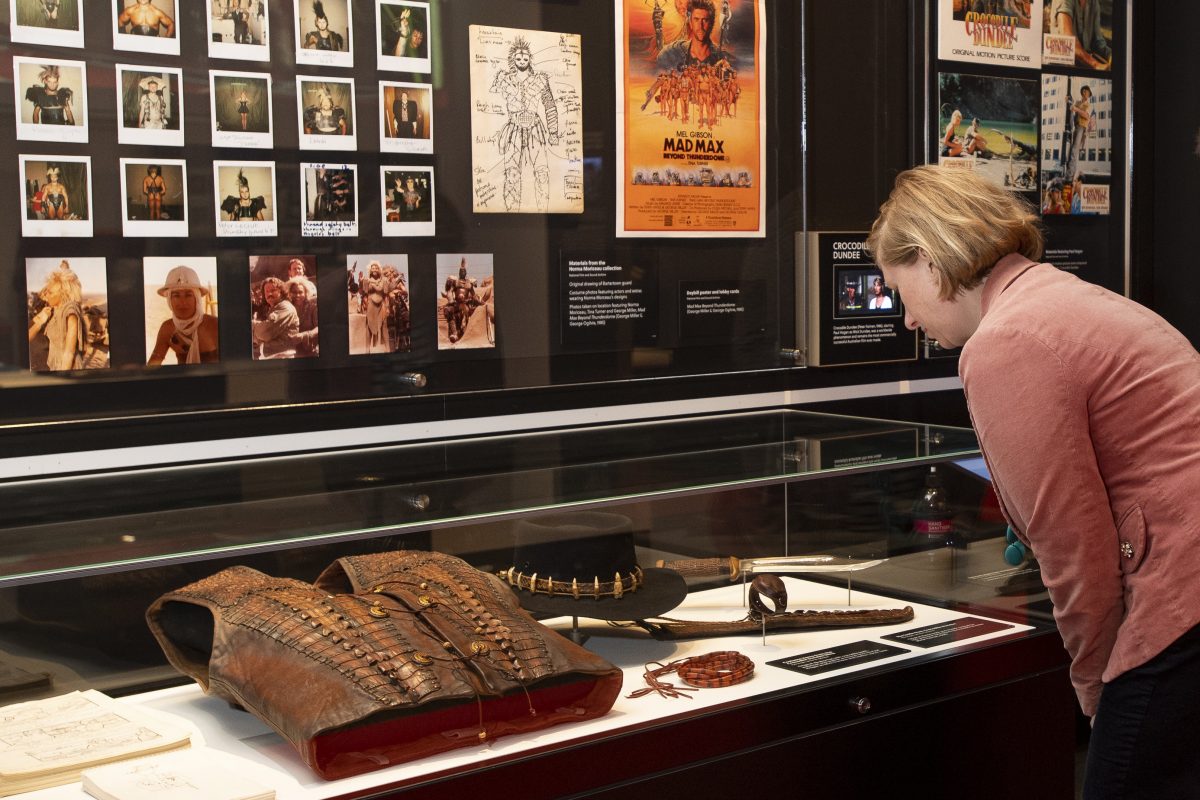Woman looks at display cabinet of artefacts at the NFSA's Australians and Hollywood exhibition.