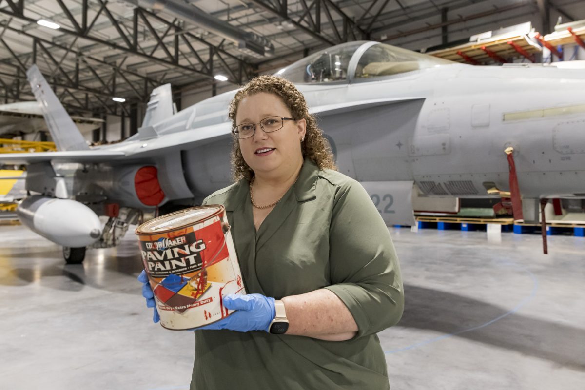 Dr Kerry Neale holding a tin of red paint