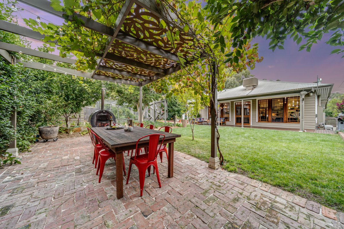 Alfresco terrace with dining area and grapevine overhead.