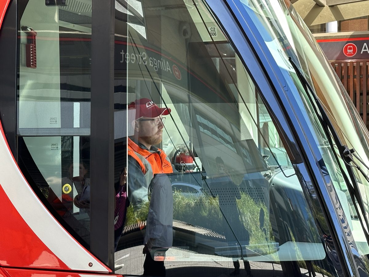 Transport Canberra train driver Matthew Vankerkoerle pictured in the driver's seat of a train.