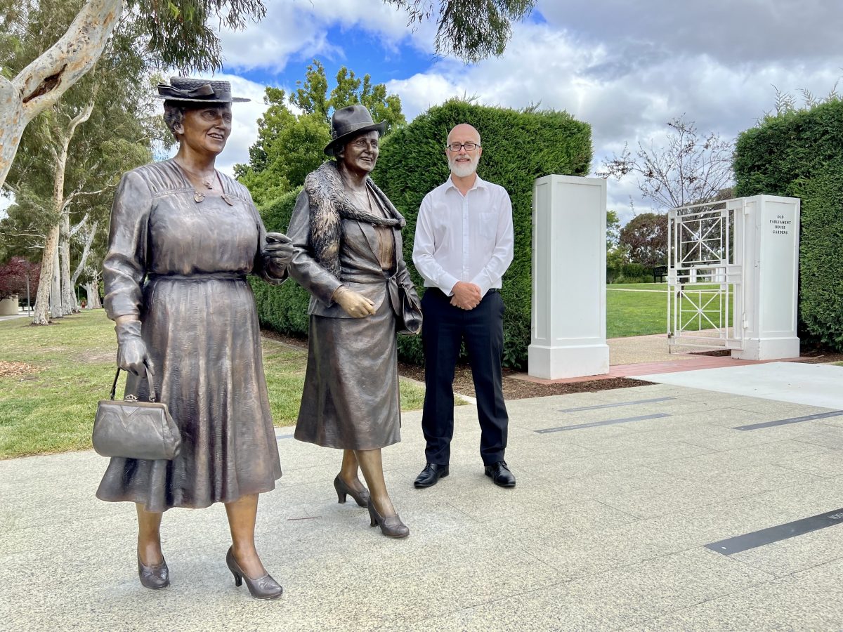 Rob Tindal standing to the right of two statues of female politicians