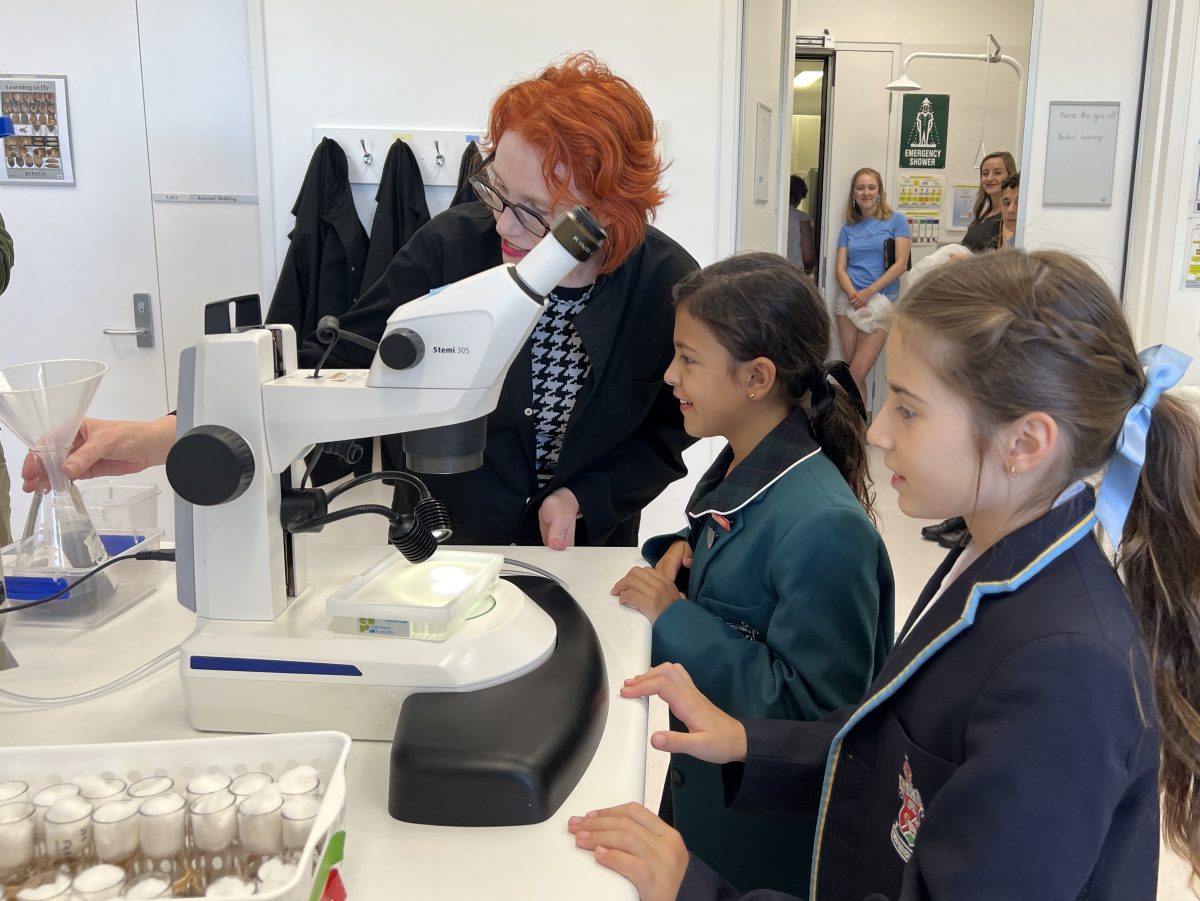 woman and two female pupils in lab