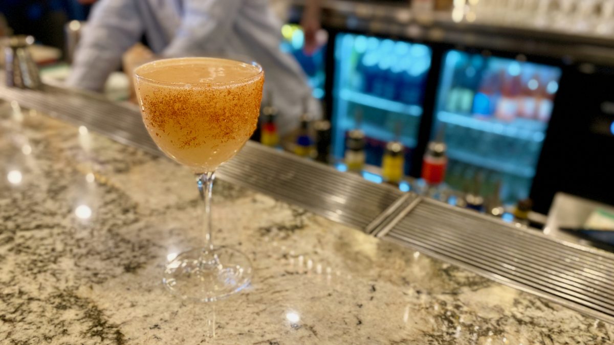 Orange coloured cocktail with chilli and salt rim