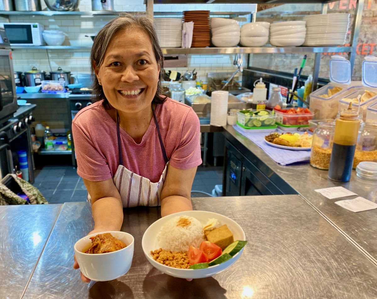 Rosa holds two bowls and smiles at the camera