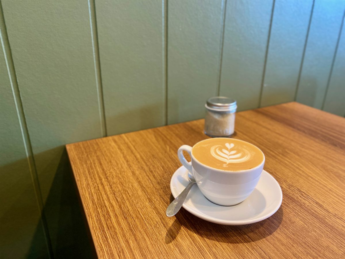 Cup of coffee against green backdrop