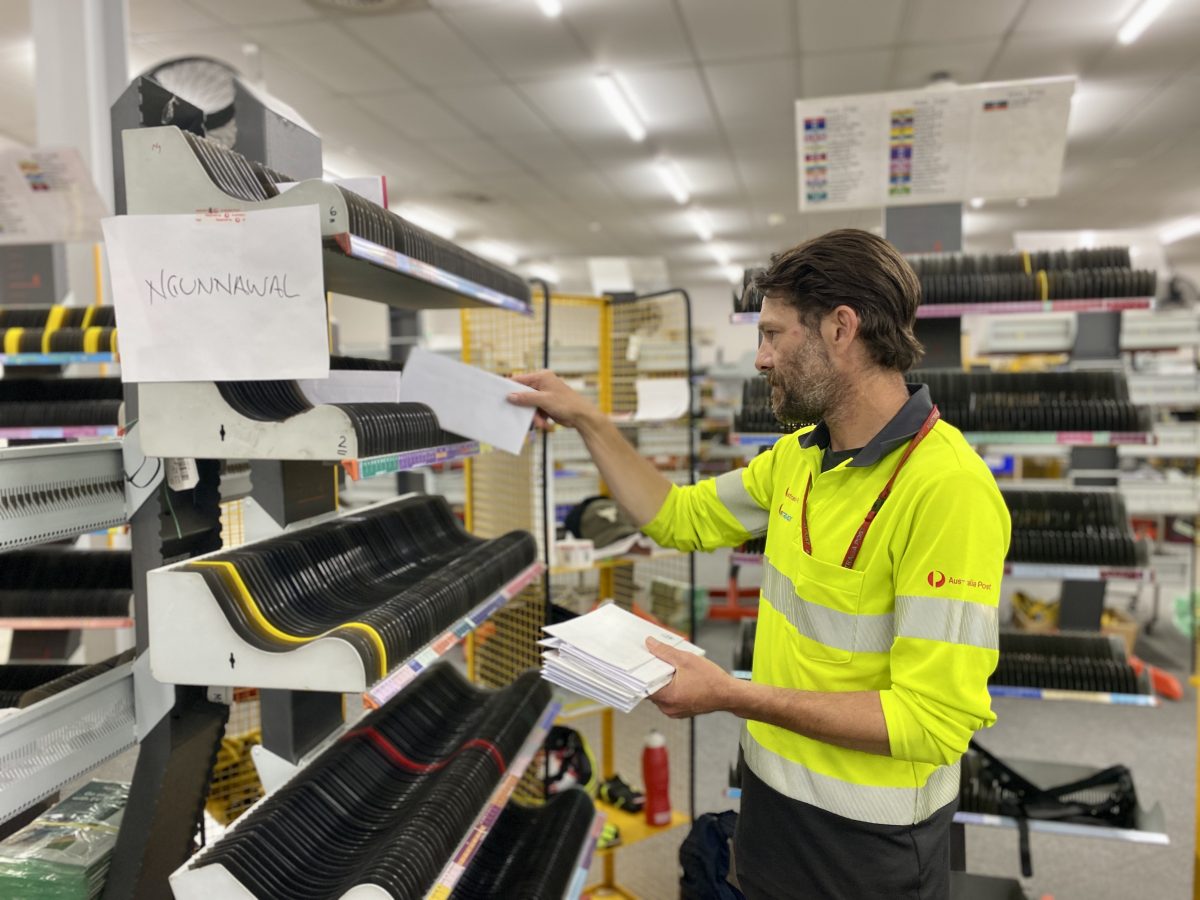 postal worker sorting mail