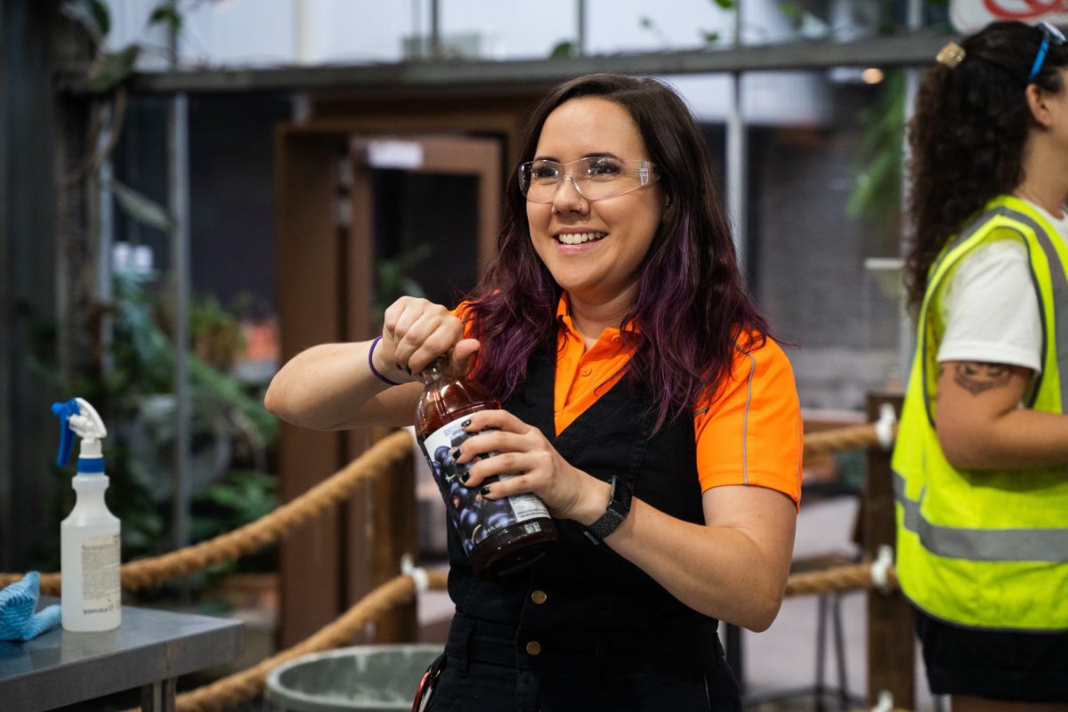 Sherri opens a bottle, smiling.