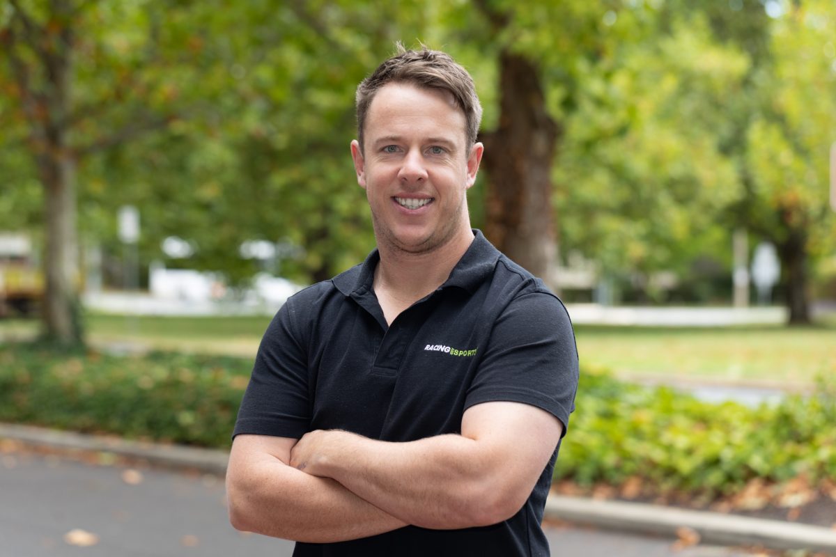 smiling man standing with arms crossed