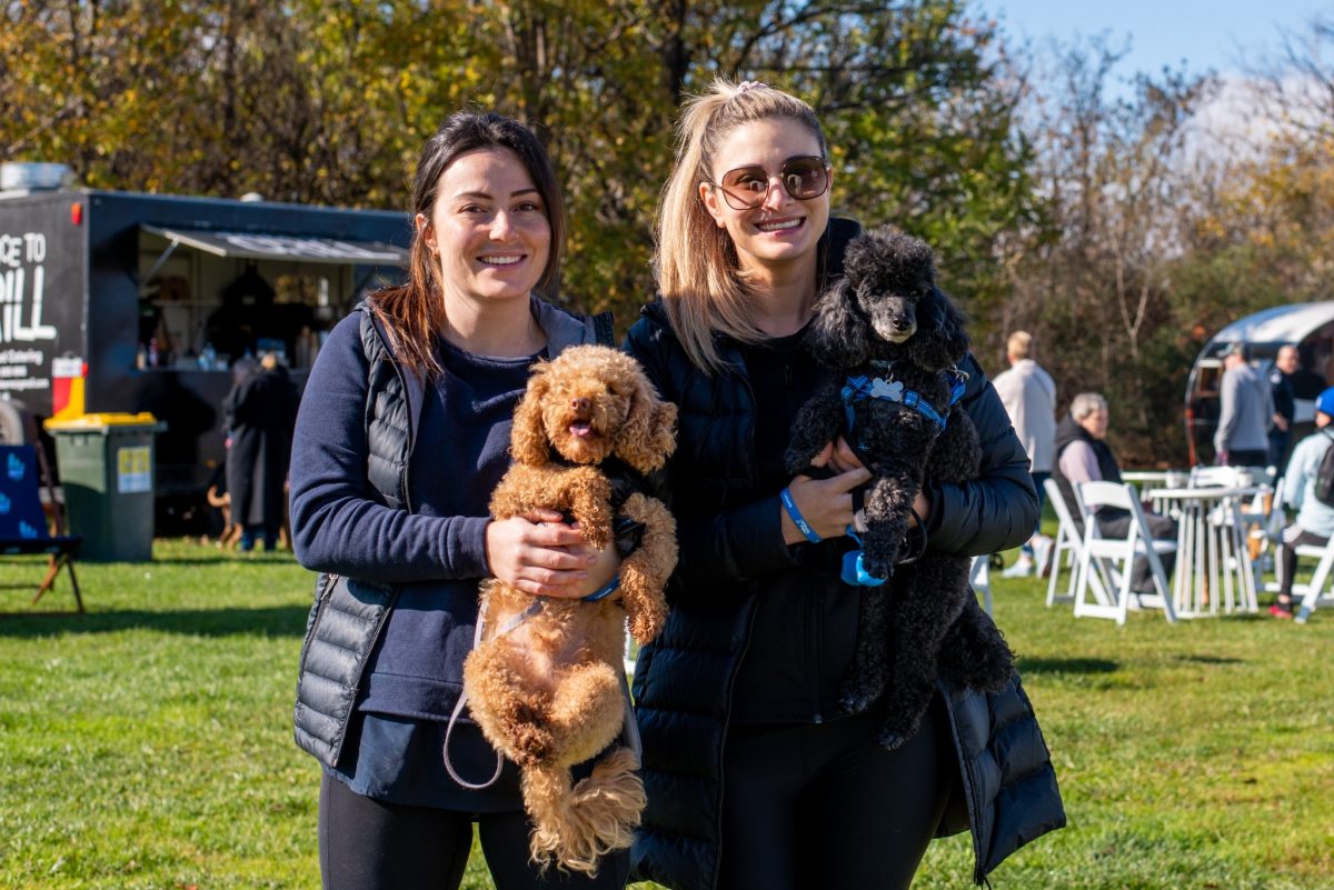 two woman holding little dogs