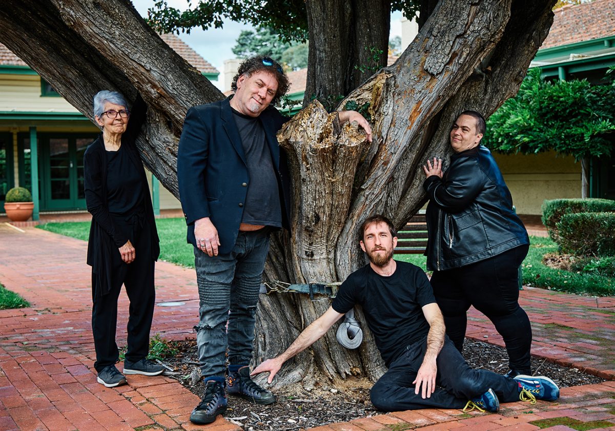 Actors pose around a tree