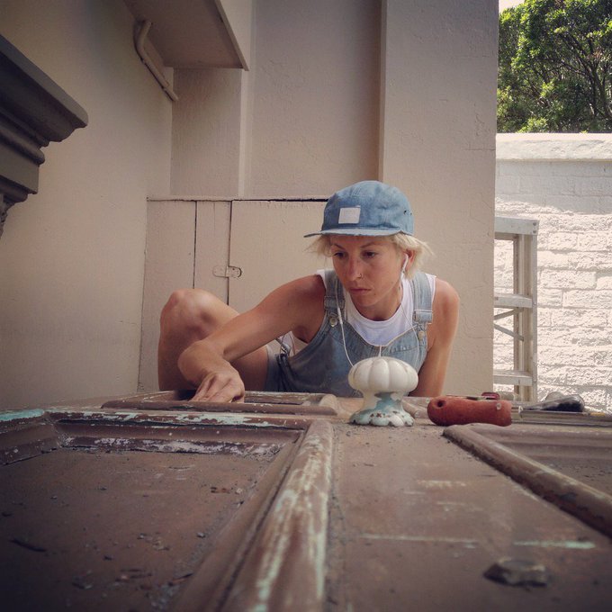 woman sanding an old door