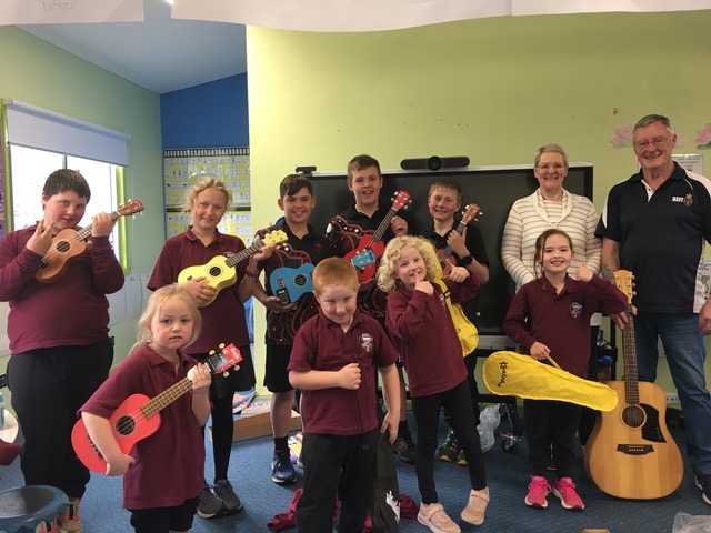 man with children holding ukeleles 