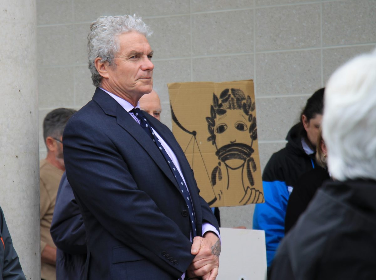 man with white curly hair outside court