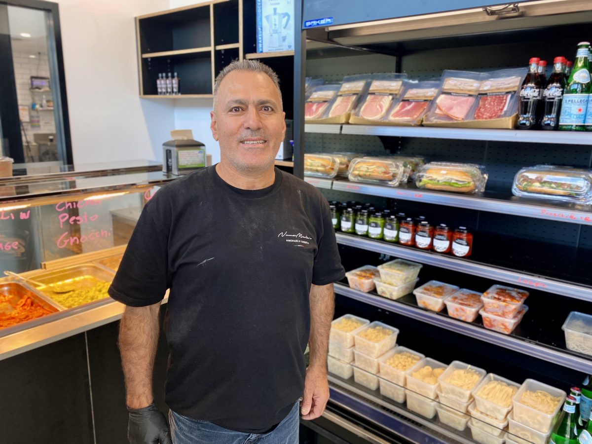 Man in black tshirt standing in front of fridge with fresh pasta