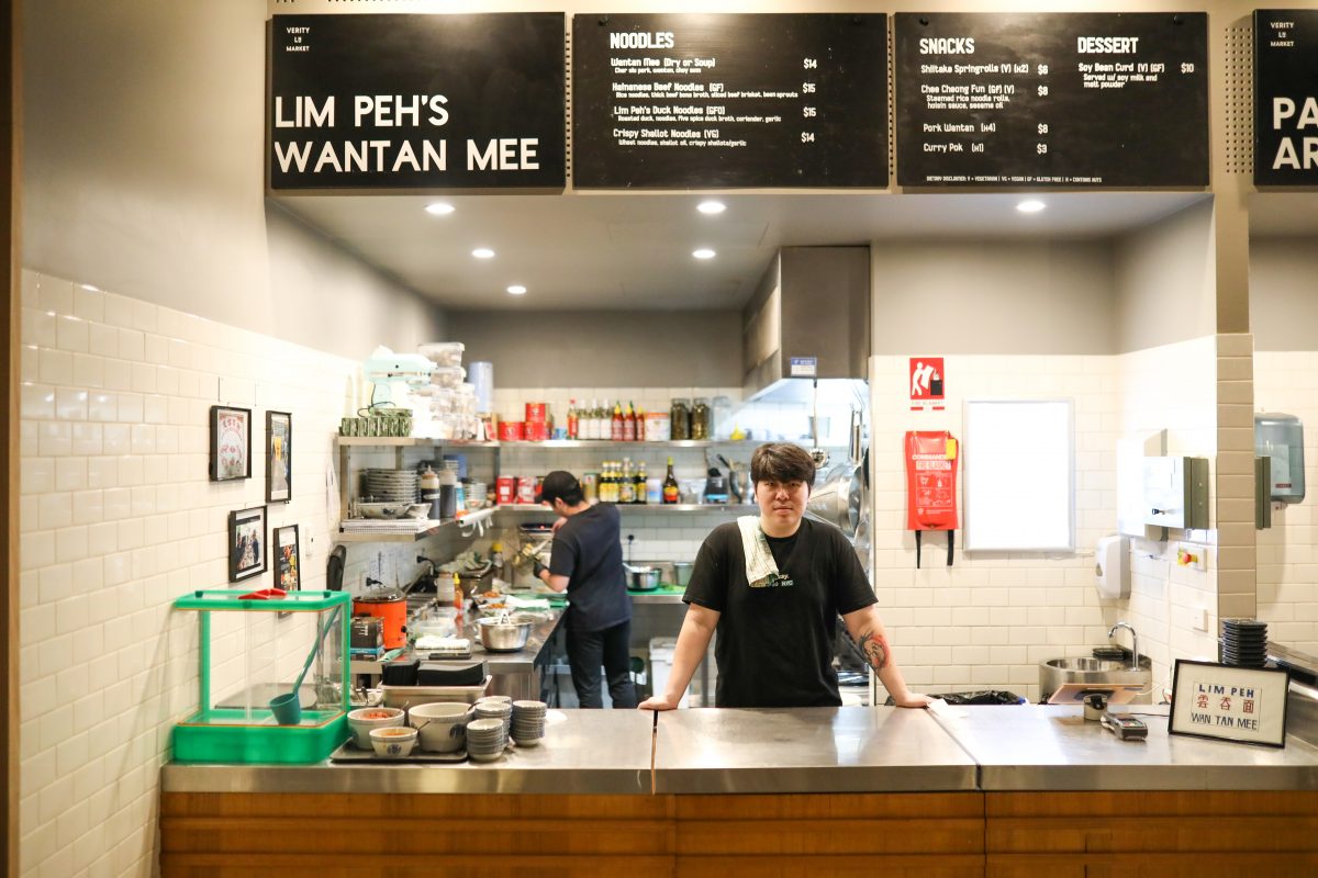 Man stands at counter of food stall