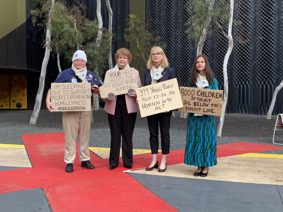 Vinnies ambassadors hold placards raising awareness of homelessness in the ACT