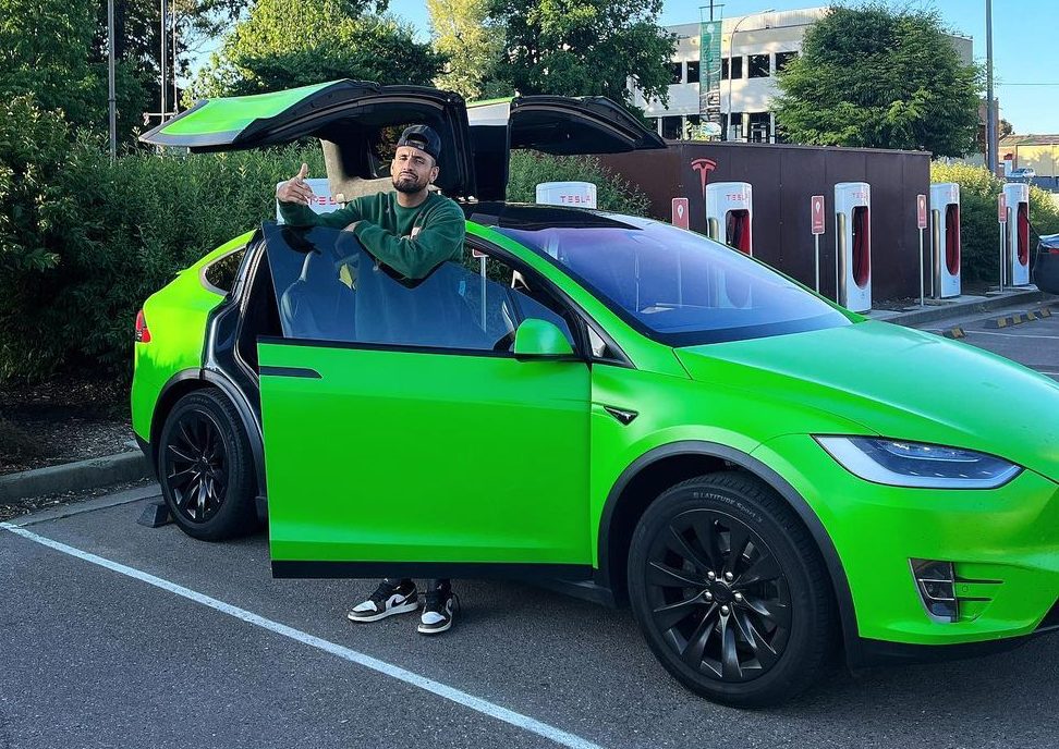 Nick Kyrgios with a green Tesla