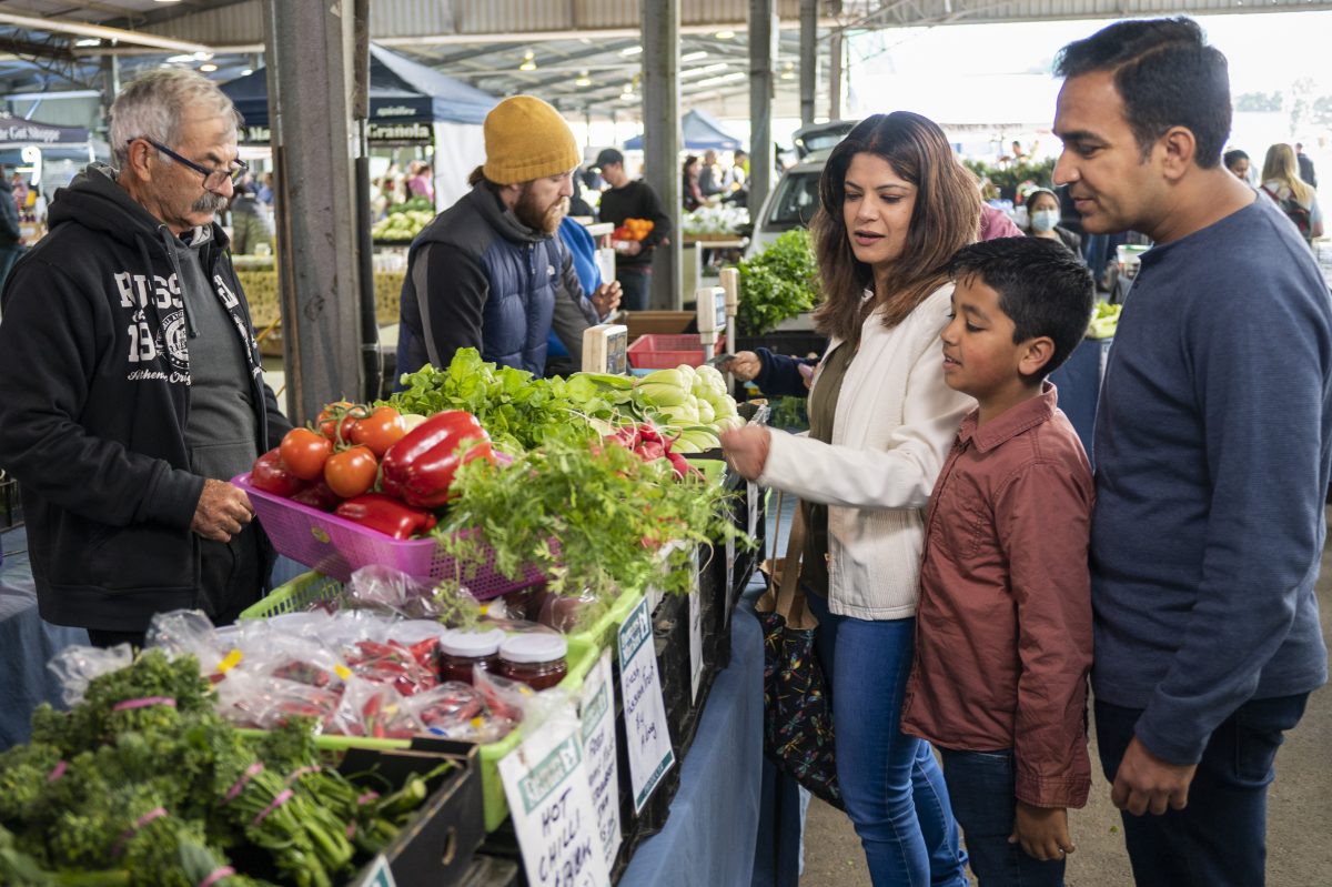 People browsing Capital Region Farmers Market stalls.