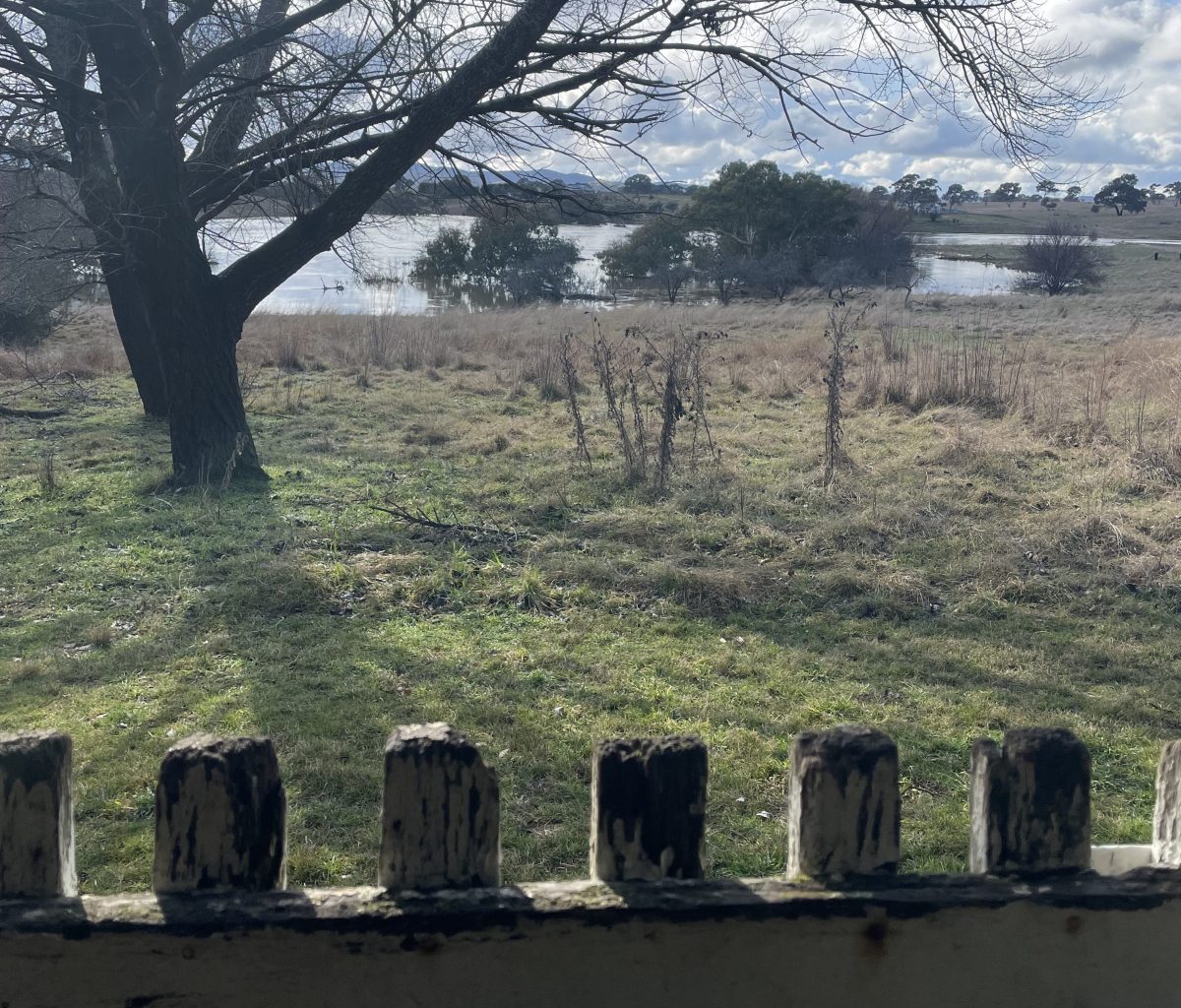 Flooded paddock rises towards farm gate