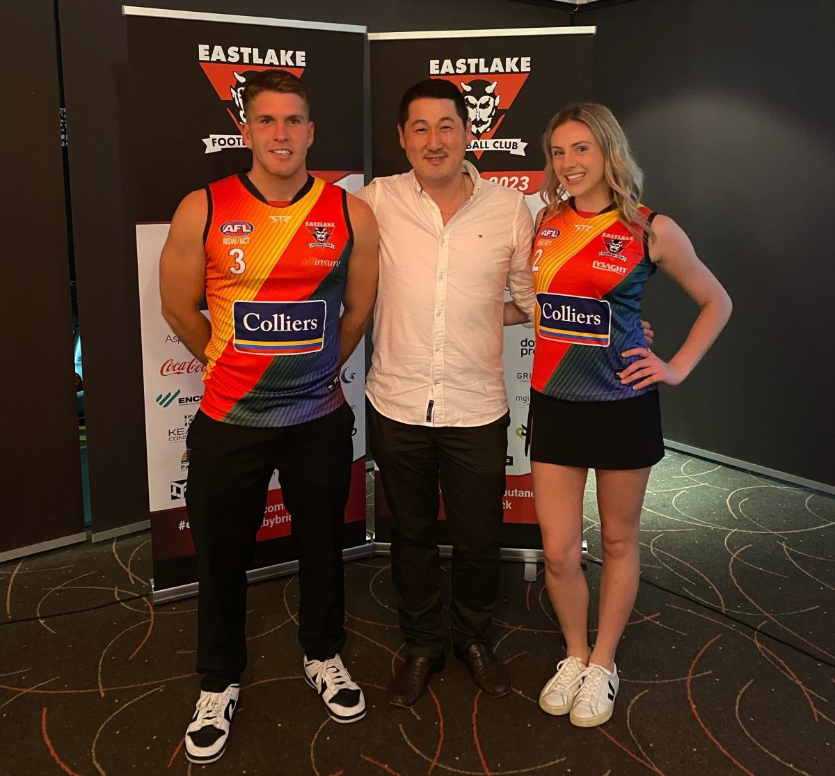 Colliers ACT head of Real Estate Management Services, Chris Park with Eastlake players Daniel Andric and Madeleine Kelly at the launch of their Pride guernsey. Photo: Eastlake AFL Club.