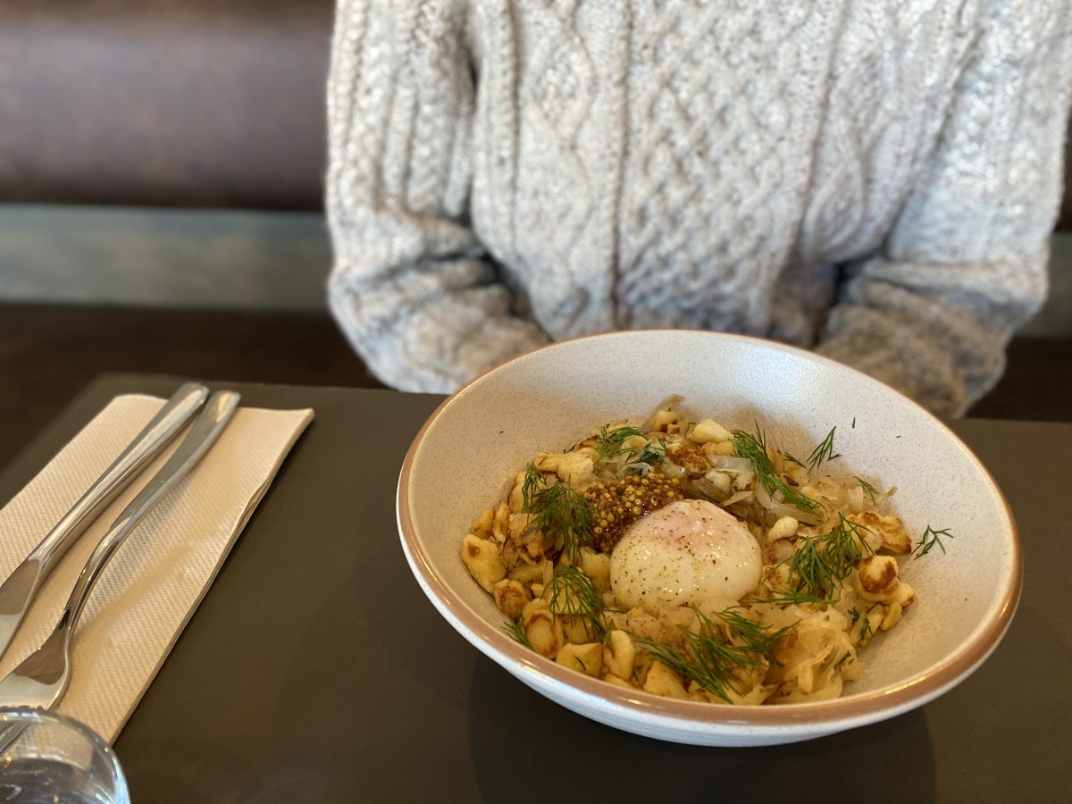 bowl of pasta with egg on table.