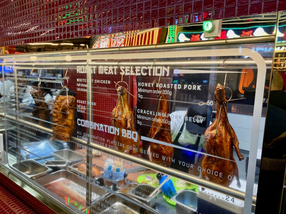 Roast meats hanging behind glass