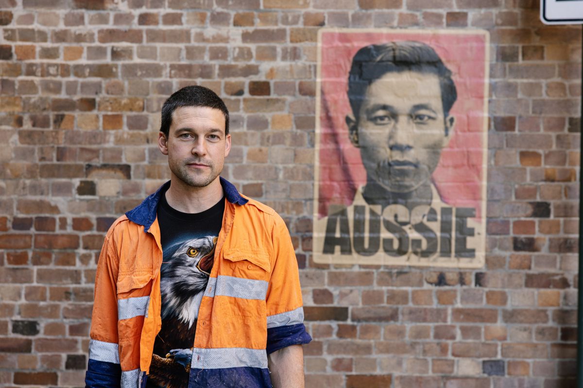 Man in front of poster.