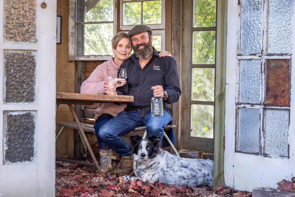 man and woman in a shed with a dog