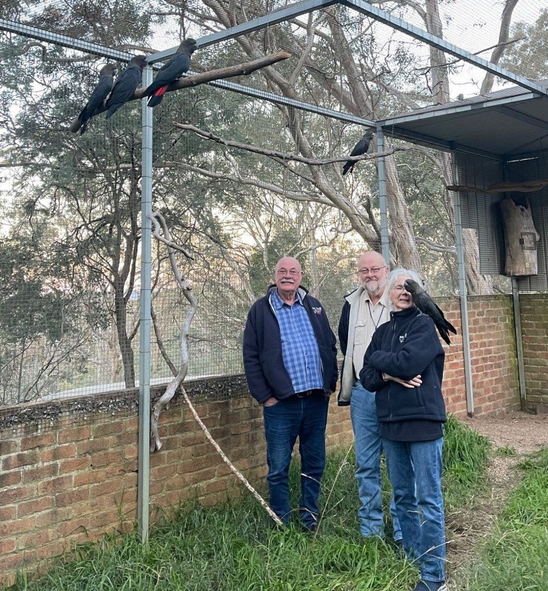 three people in bird enclosure