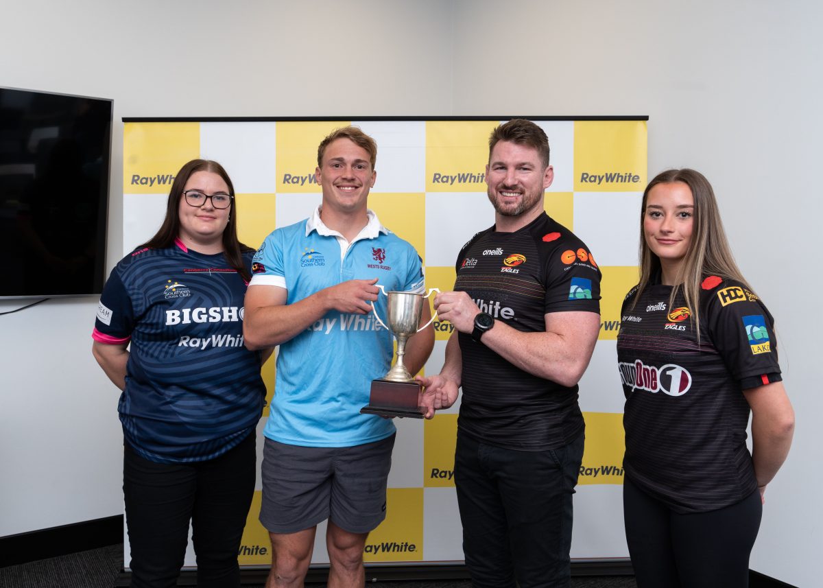 two men and two women with a trophy