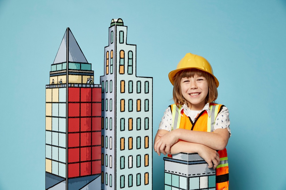 Girl in hard hat next to buildings