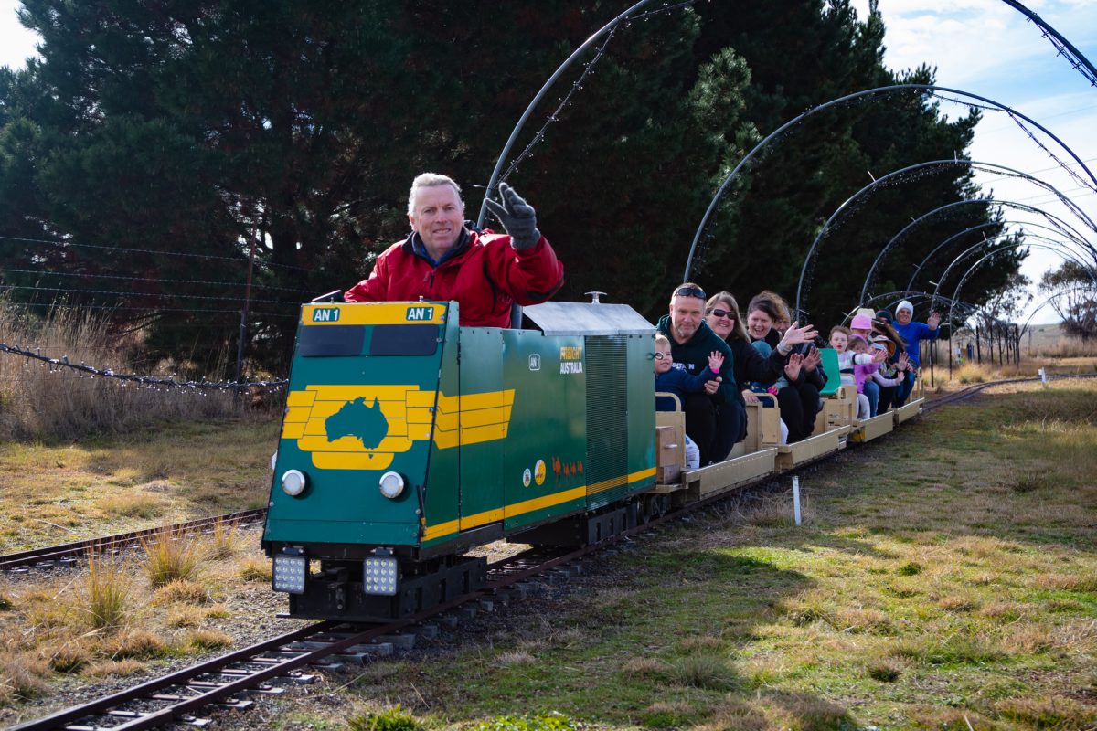 A miniature train driver waving as the train goes by