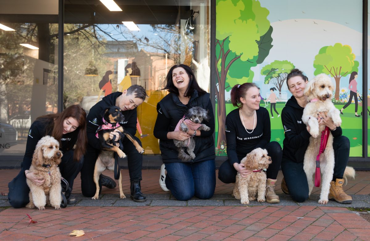 Dogs posing with their owners in front of The Waggington