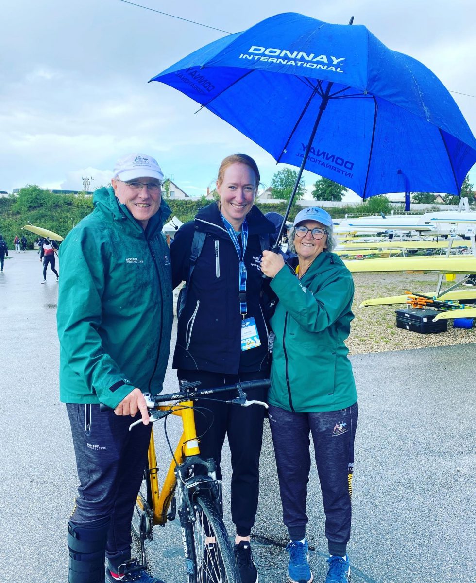 man and two women under an umbrella 