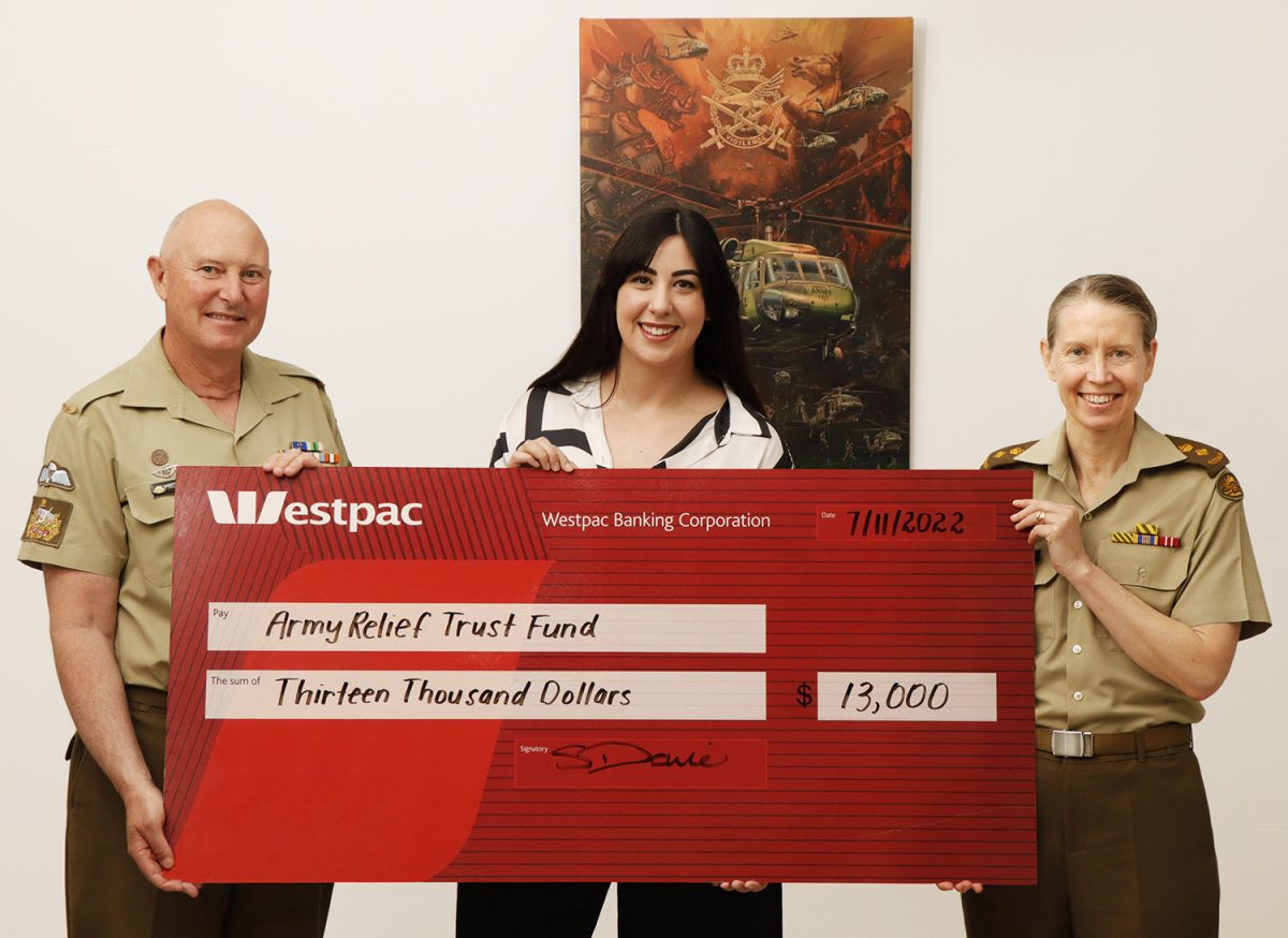 man and two women holding a large cheque 